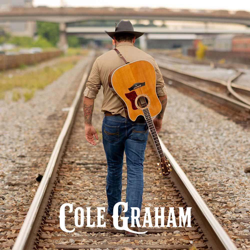 A man wearing a cowboy hat, tan shirt, and blue jeans walks away on railroad tracks while carrying an acoustic guitar over his shoulder. The text 'Cole Graham' is overlaid at the bottom.